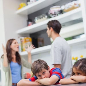 Image of a family at the kitchen table, arms crossed, showing signs of conflict - THE LAW OFFICES OF DIANE ANDERSON